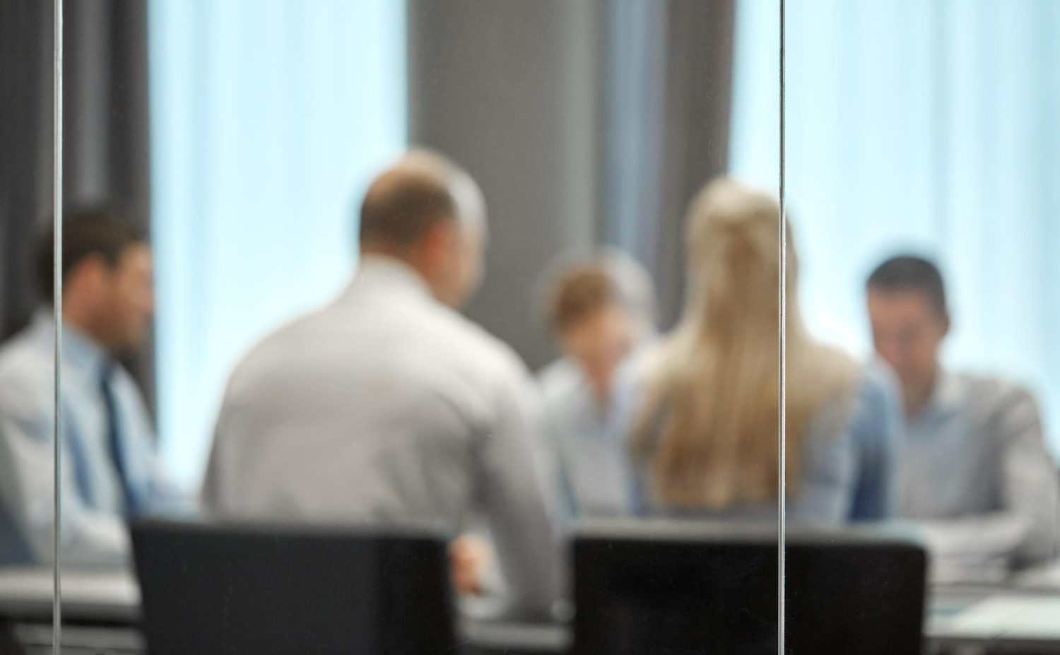 Marketing ROI formula discussion in office meeting through glass divider